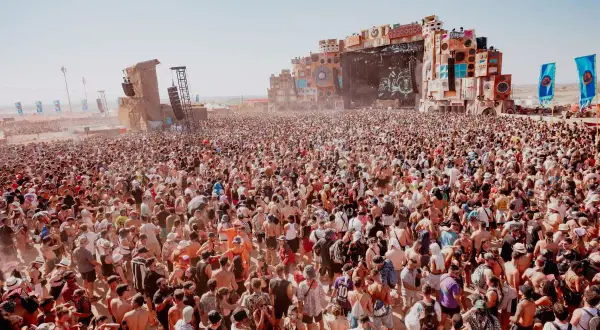 Multitudinaria asistencia al Monegros Festival, con miles de personas disfrutando de la música y el ambiente bajo un sol radiante.