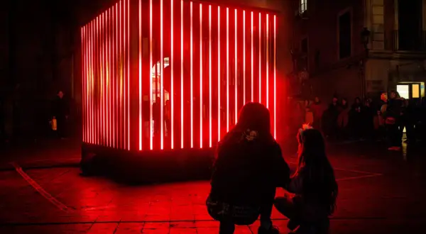 Dos personas observan una instalación de luces rojas en Zaragoza, un adelanto de lo que Zaragoza luce 2026.