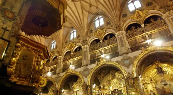 Interior del real seminario de San Carlos, con altares dorados, arcos ornamentados y techos abovedados.