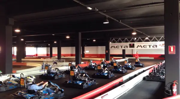 Carreras de **karting Puerto Venecia**. Varios karts listos en la pista, algunos con pilotos preparándose para la acción.