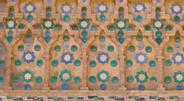 Detalle de azulejos de la Seo Zaragoza, con estrellas de ocho puntas en azul y verde sobre fondo de ladrillo y detalles circulares.