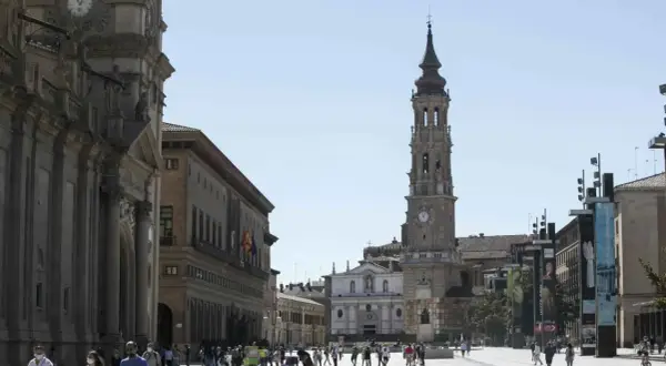 Plaza del Pilar en Zaragoza, con la imponente iglesia de la Seo y el Ayuntamiento. Gente paseando bajo el sol.