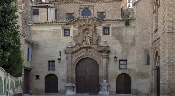 Fachada de la iglesia de las canonesas del Santo Sepulcro, con su gran portalón de madera y una escultura en el nicho central.