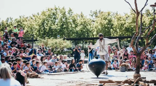 Un artista hace girar una peonza gigante ante un público atento. ¡Utebo respira circo!