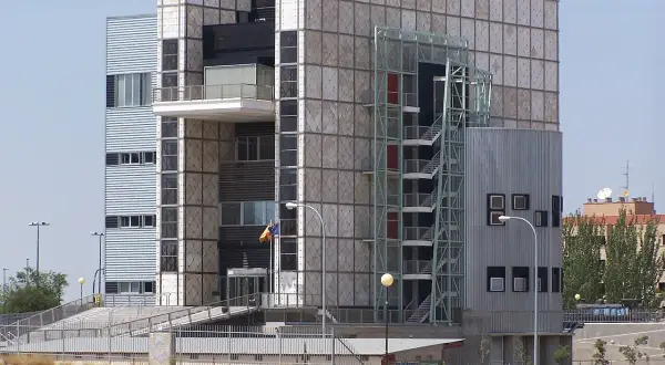 Edificio crea con fachada de paneles cuadrados y una escalera exterior metálica.