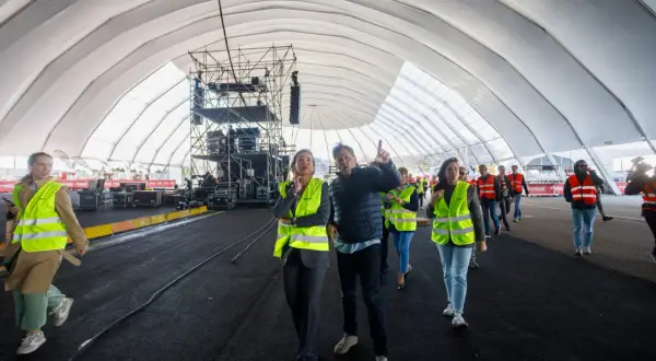 Gente con chalecos fluorescentes revisa montaje en carpa para ferias Valdespartera. Así se llega al evento.