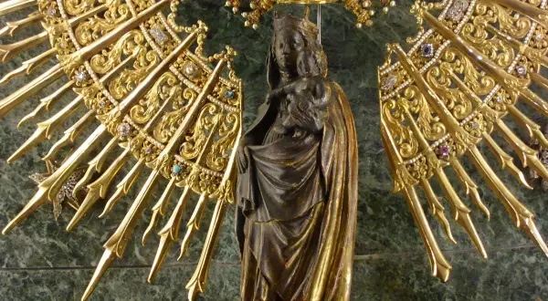 Virgen con Niño, rodeada de un resplandor dorado y joyas, evocando la solemnidad de cuando es la Pilarica.