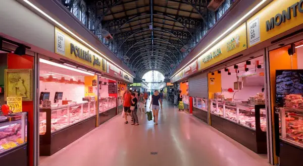 Pasillo del mercado San Miguel Zaragoza, con puestos de carne y pollo, gente comprando.