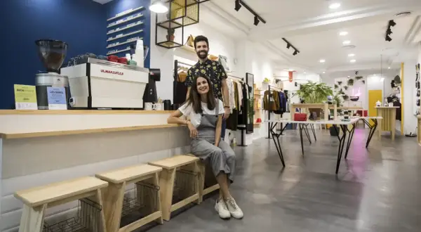 Pareja sonriente en una cafetería y tienda de moda en Zaragoza. Ambiente moderno y acogedor.
