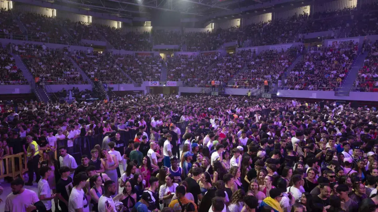Multitud vibrante en el Pabellón Príncipe Felipe para disfrutar de conciertos. El recinto está lleno de gente, creando un ambiente festivo.