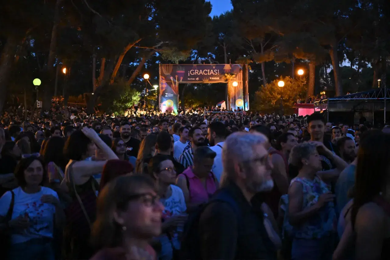 Multitud disfrutando de música al raso Zaragoza bajo un arco de agradecimiento.