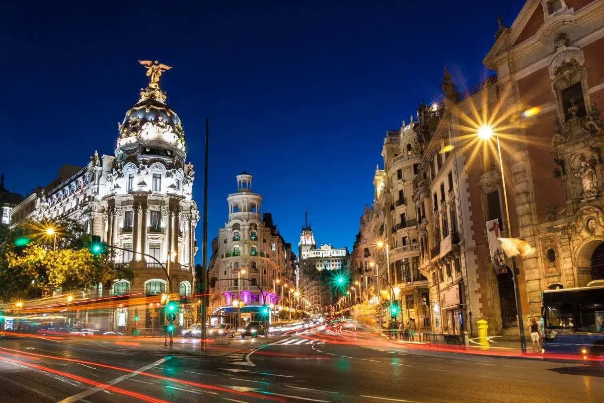 Noche en Gran Vía, Madrid. Edificios iluminados y luces de coches crean un ambiente vibrante. Un lugar ideal que ver en Madrid centro.