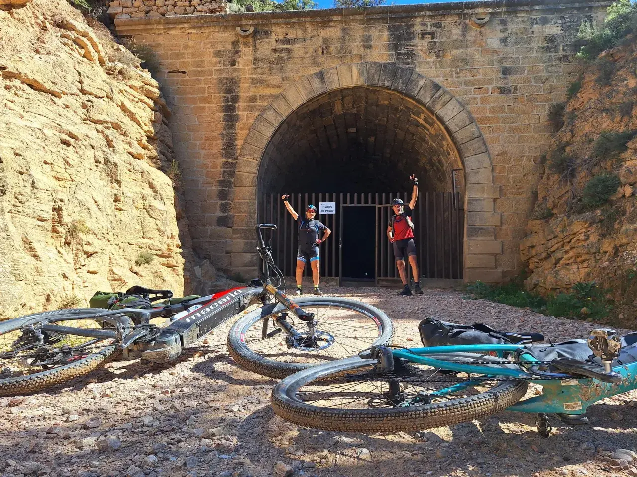 Ciclistas posan ante un túnel, una parada interesante que ver cerca de Alcañiz.