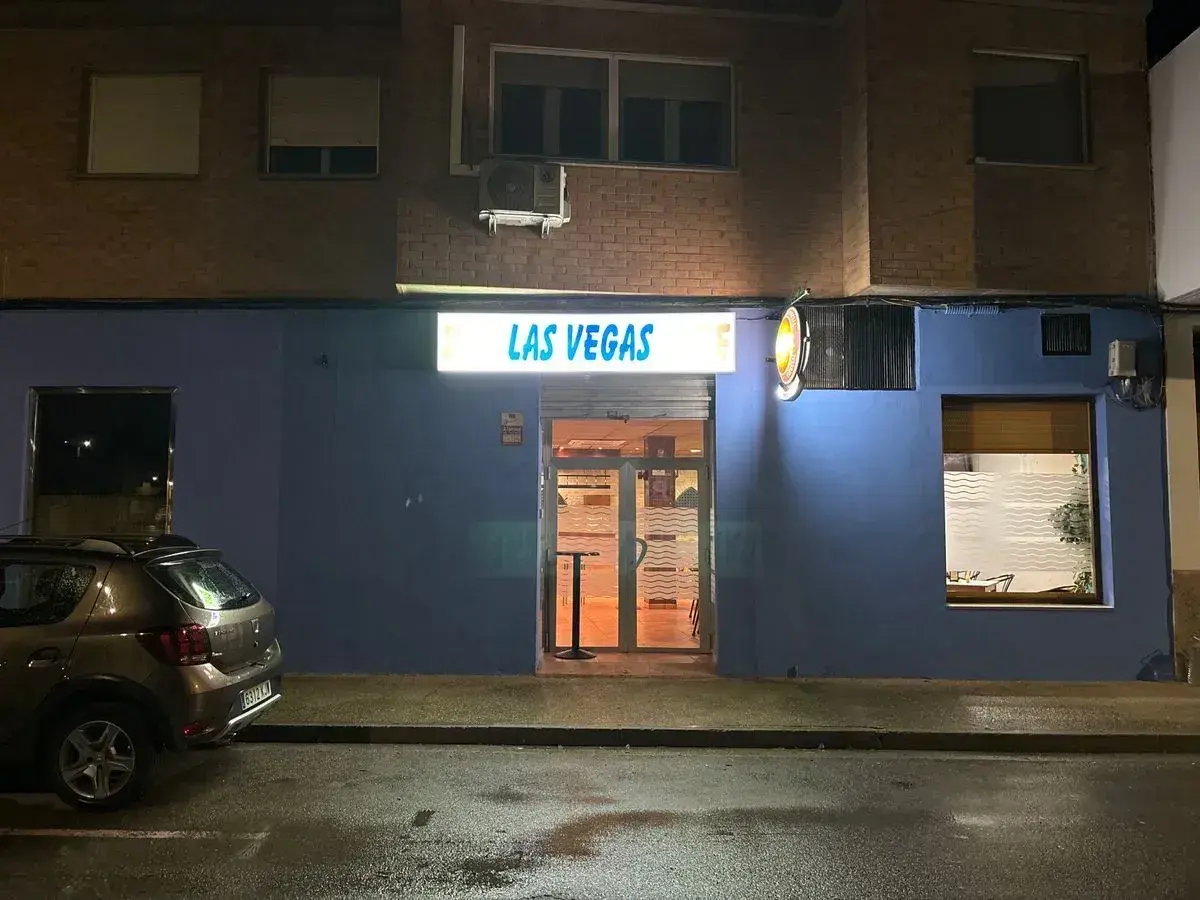 Fachada de "Las Vegas" en Zaragoza, con un coche aparcado y la calle mojada.