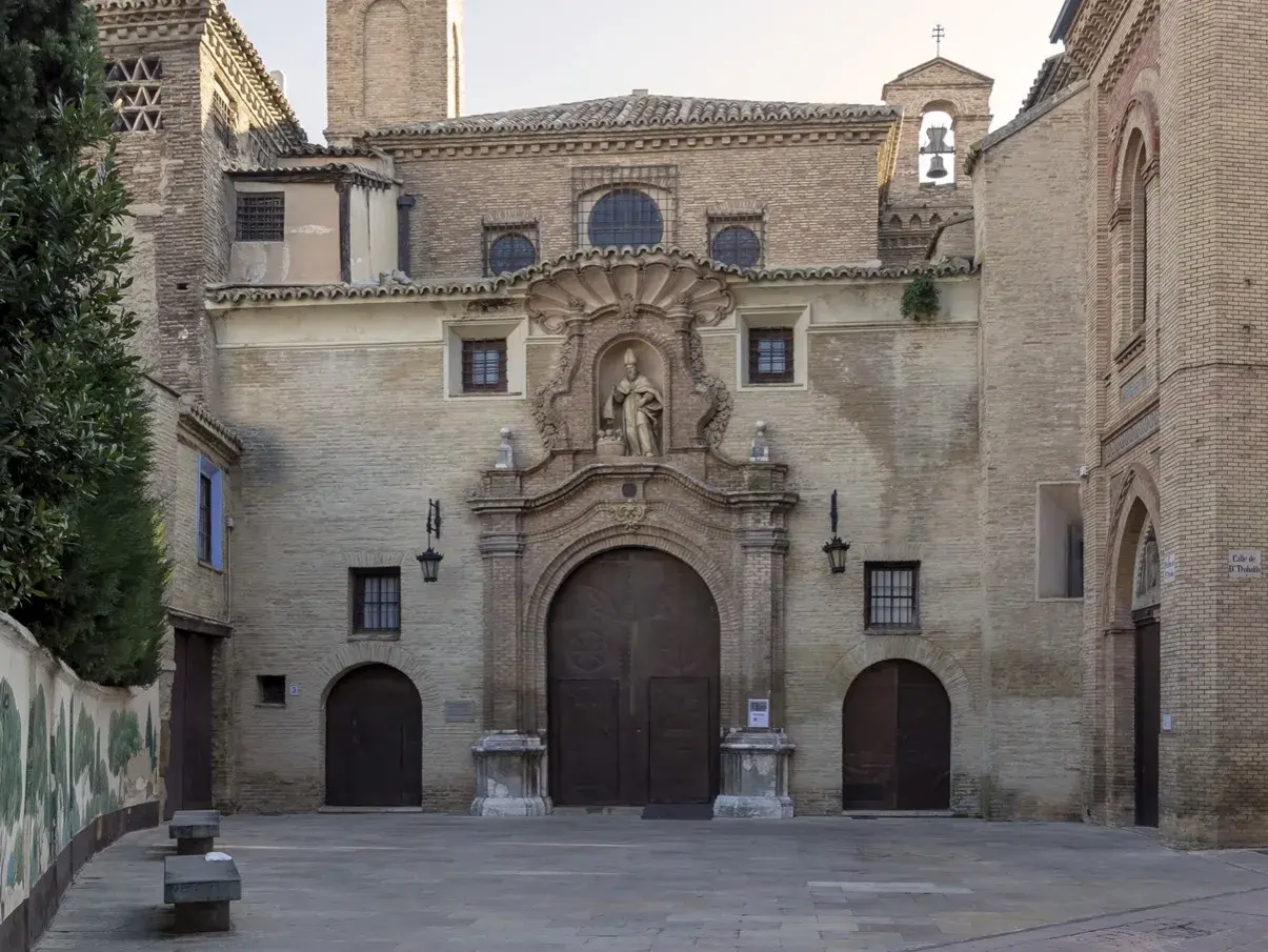 Fachada de la iglesia de las canonesas del Santo Sepulcro, con su gran portalón de madera y una escultura en el nicho central.