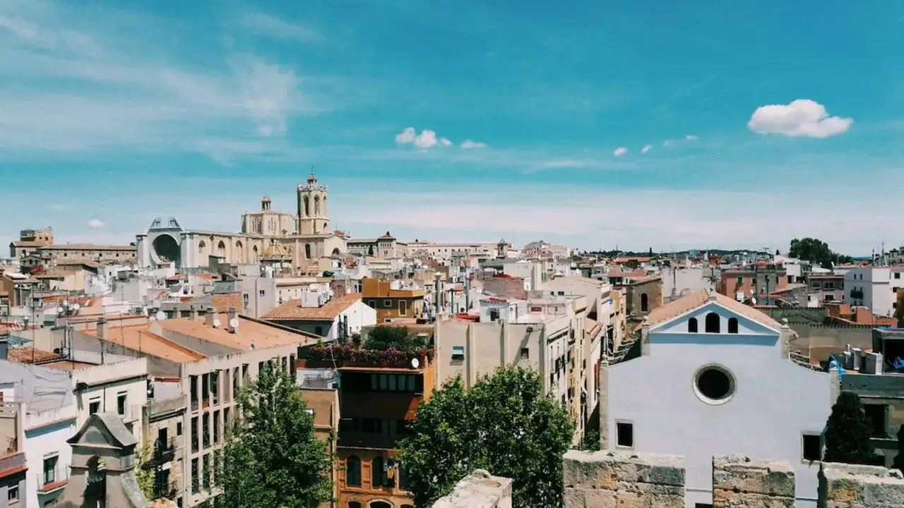 Vista panorámica de Tarragona, ideal para un retiro espiritual en Cataluña. Cielo azul con nubes y edificios históricos.