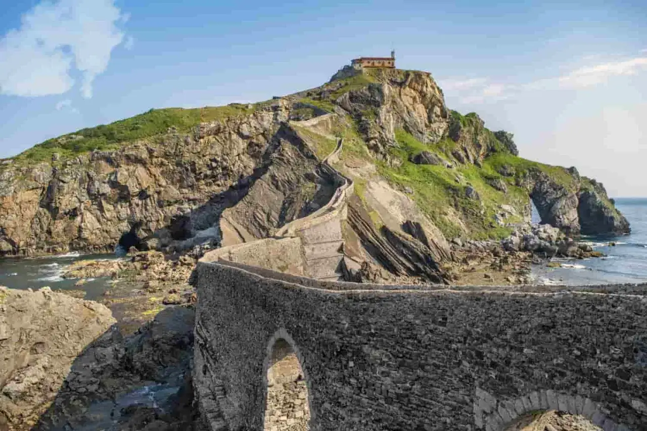 Escaleras de piedra serpentean hacia una ermita en la cima de un acantilado rocoso. Un lugar increíble que ver cerca de Bilbao.
