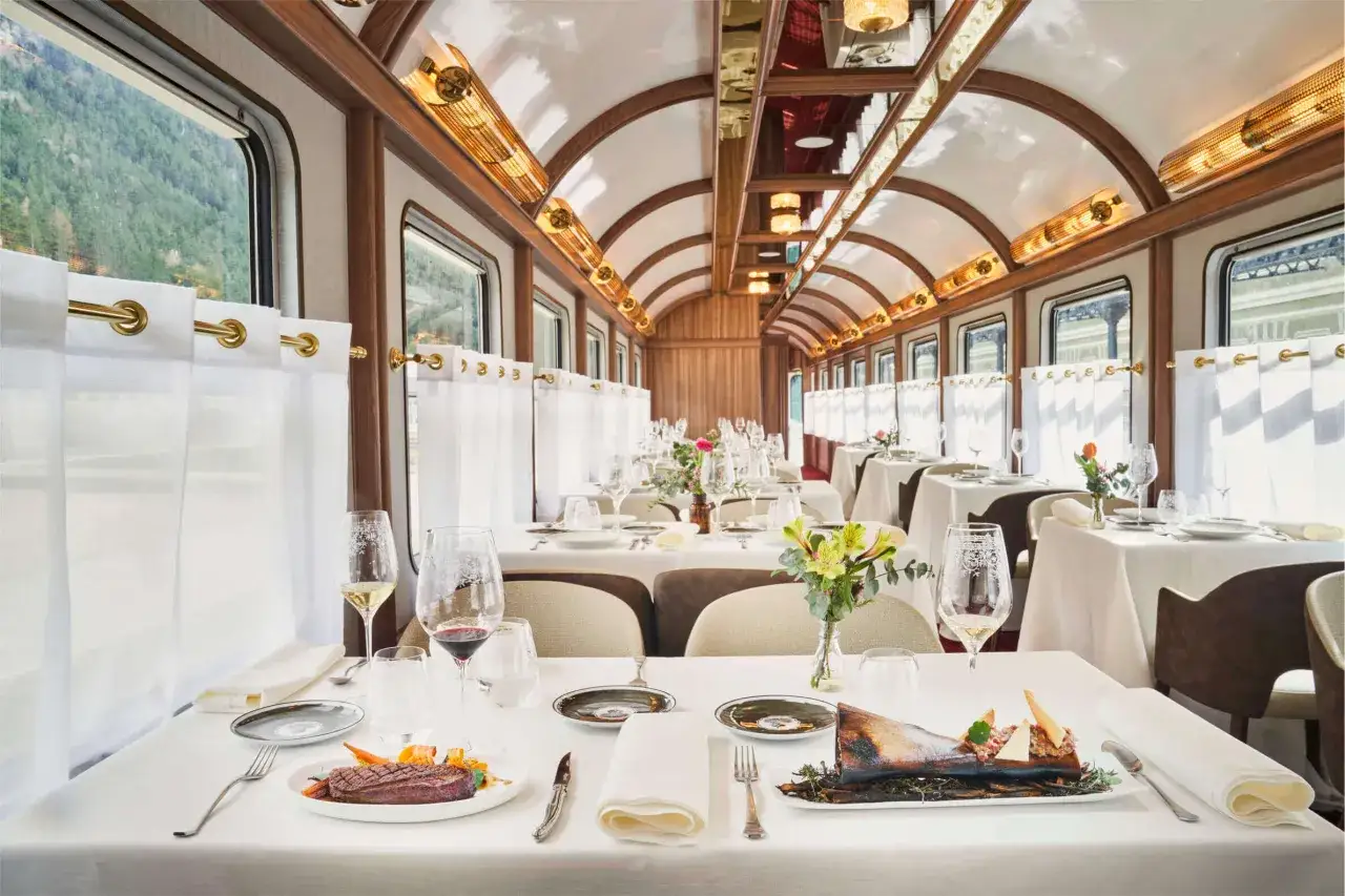 Elegante vagón restaurante del Canfranc Express, con mesas puestas, vistas a la montaña y una experiencia culinaria de lujo.