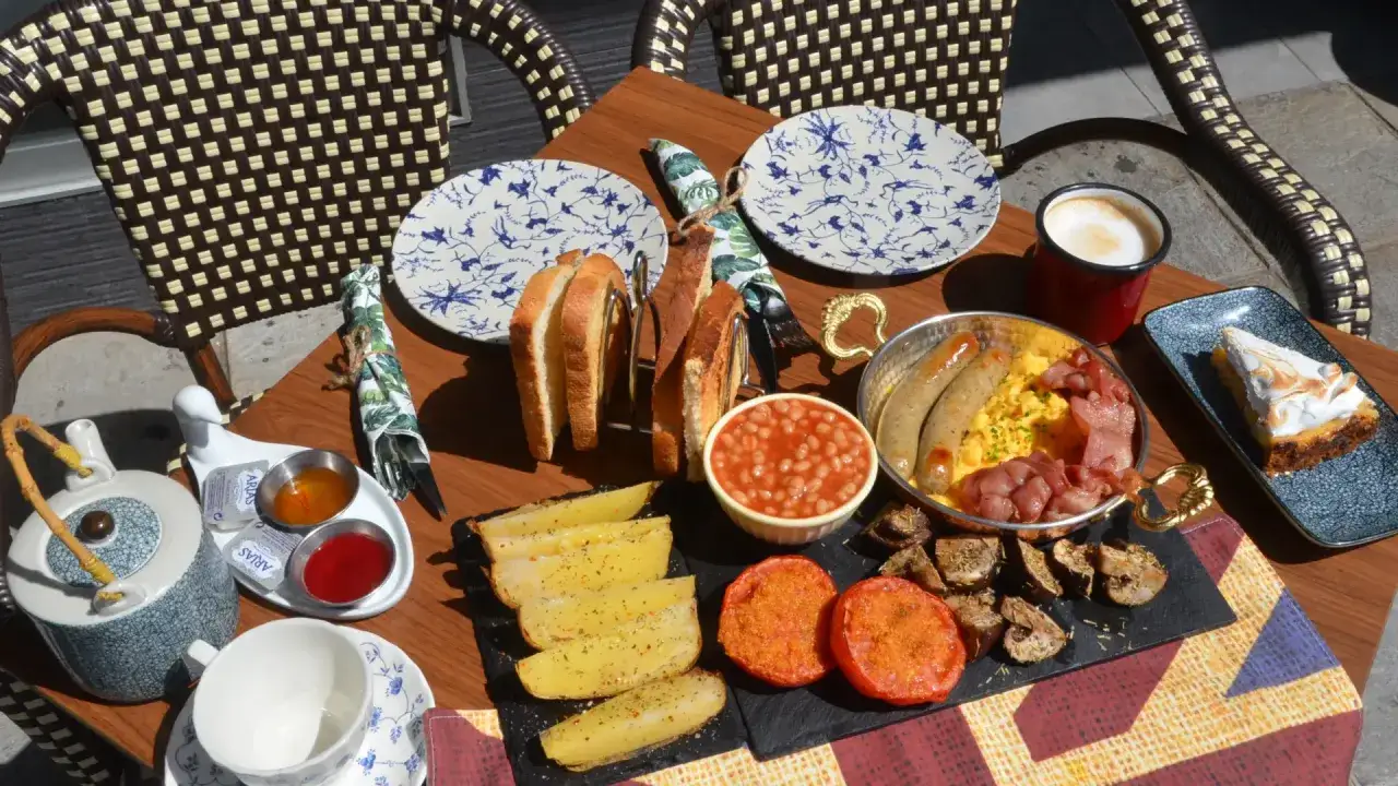 Desayuno completo en una de las cafeterias Zaragoza: tostadas, huevos, salchichas, bacon, judías, patatas, tomate y tarta de limón.