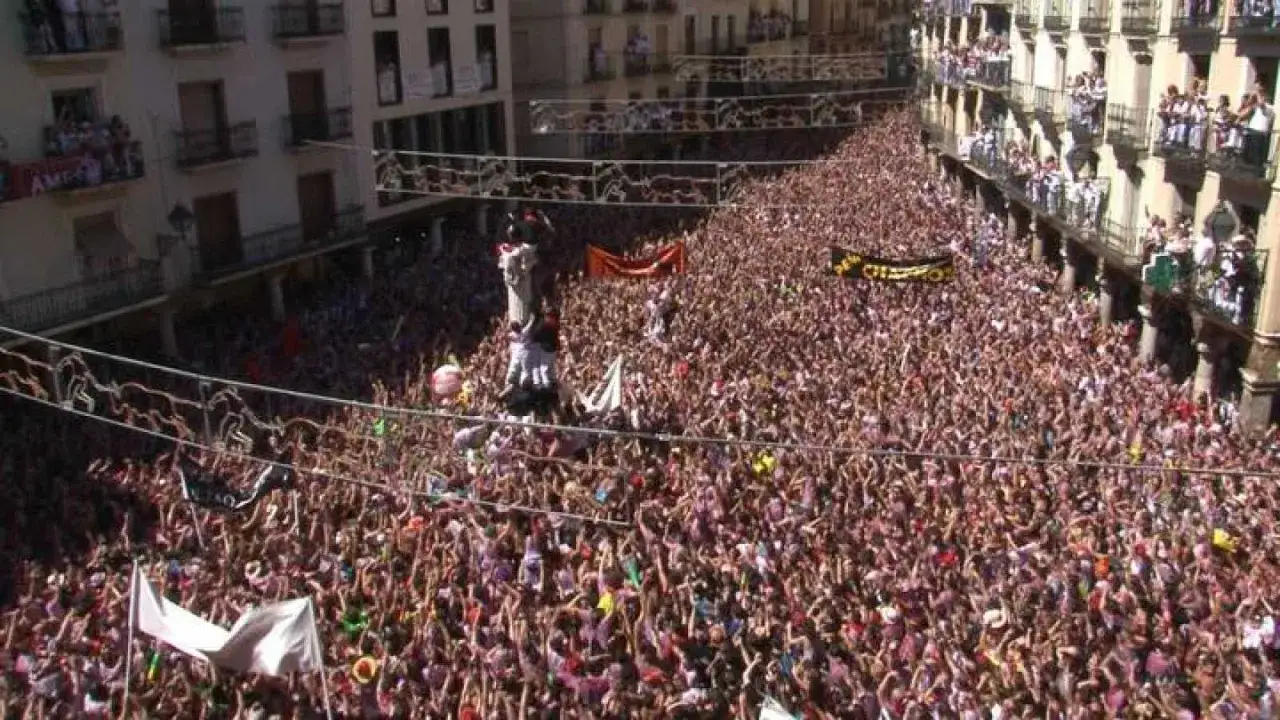 Multitud celebrando el programa fiestas Teruel. Banderas y gente animando en las calles.