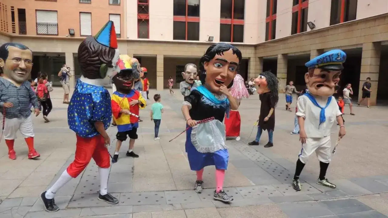 Gigantes y cabezudos desfilan en el programa fiestas delicias. Personajes con cabezas enormes y trajes coloridos alegran la plaza.
