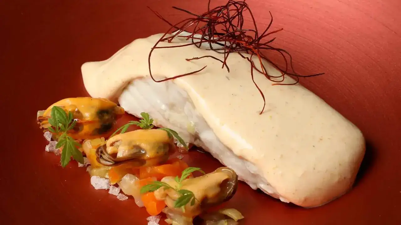 Delicioso plato de pescado con mejillones y salsa cremosa, digno de estrellas Michelin Zaragoza.