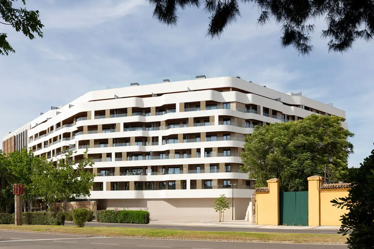 Edificio moderno con balcones curvos y fachada blanca, ubicado cerca de la plaza María Agustín Zaragoza.