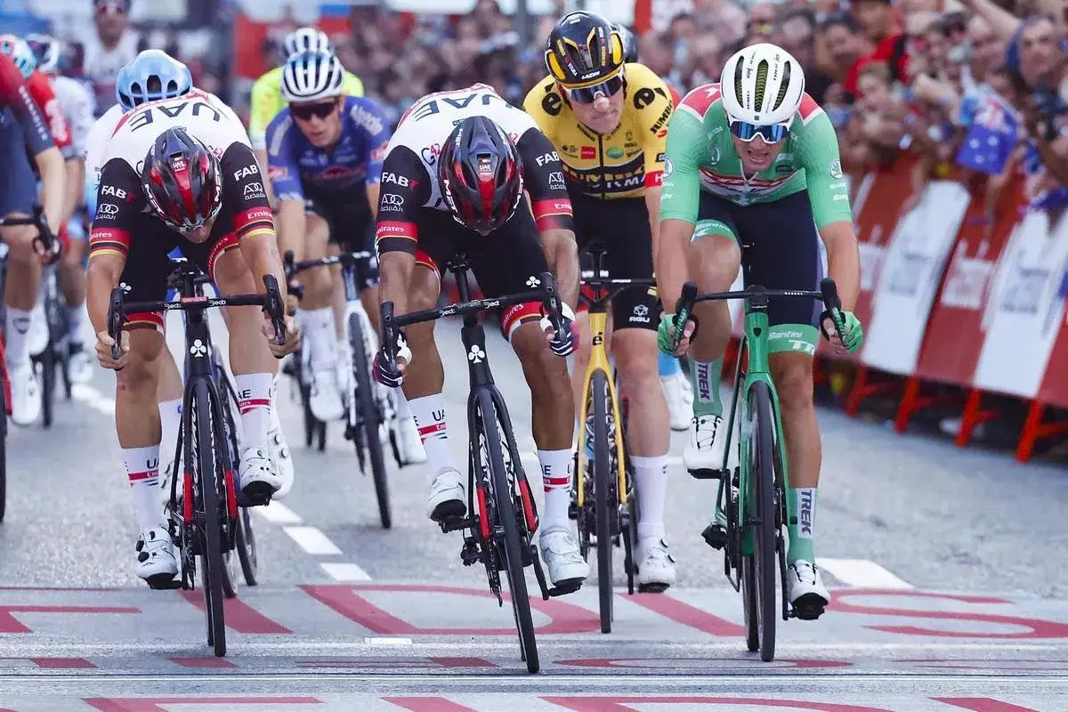 Ciclistas compiten en la meta de la vuelta ciclista España Zaragoza. El corredor con maillot verde lidera la llegada.