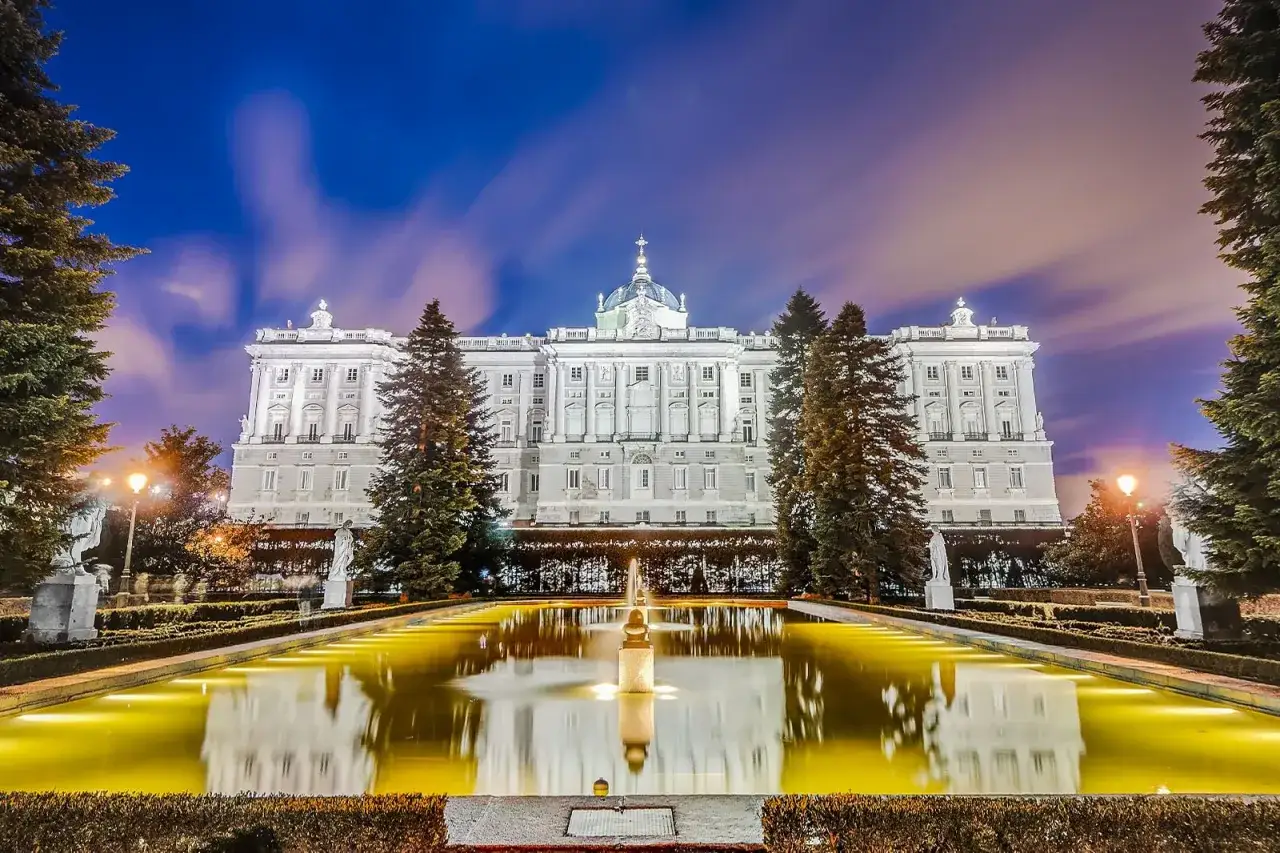 Palacio Real de Madrid de noche, con su reflejo en la fuente iluminada. Un lugar imprescindible que ver en Madrid centro.