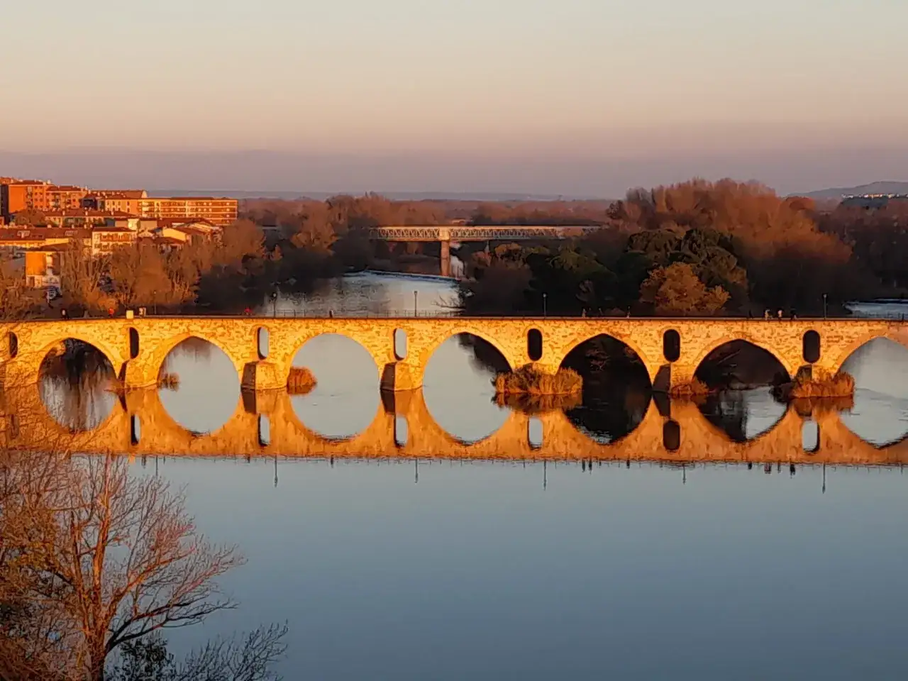 Puente de piedra con reflejo perfecto en el r&iacute;o Duero al atardecer. Merece la pena visitar Zamora por su belleza.