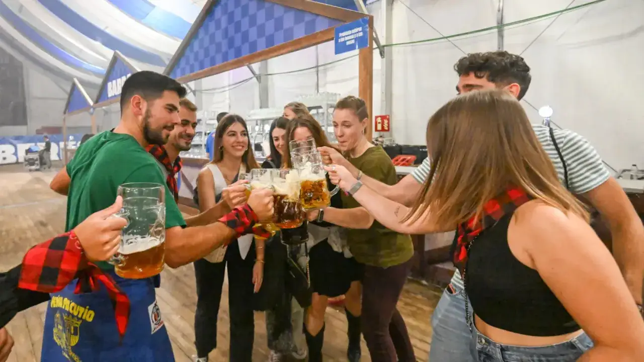Amigos brindan con jarras de cerveza en el oktober valdespartera.