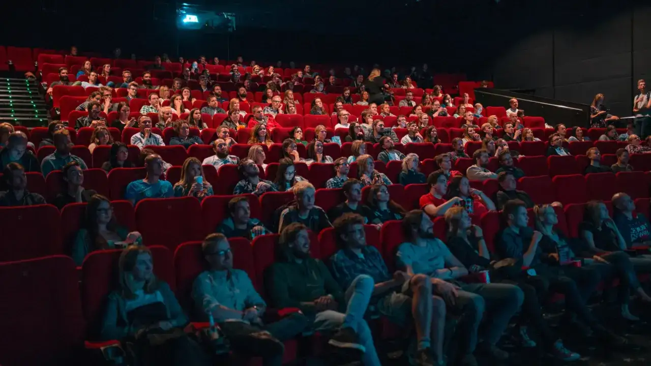 Público atento en una sala de cine, disfrutando de la semana del cine.