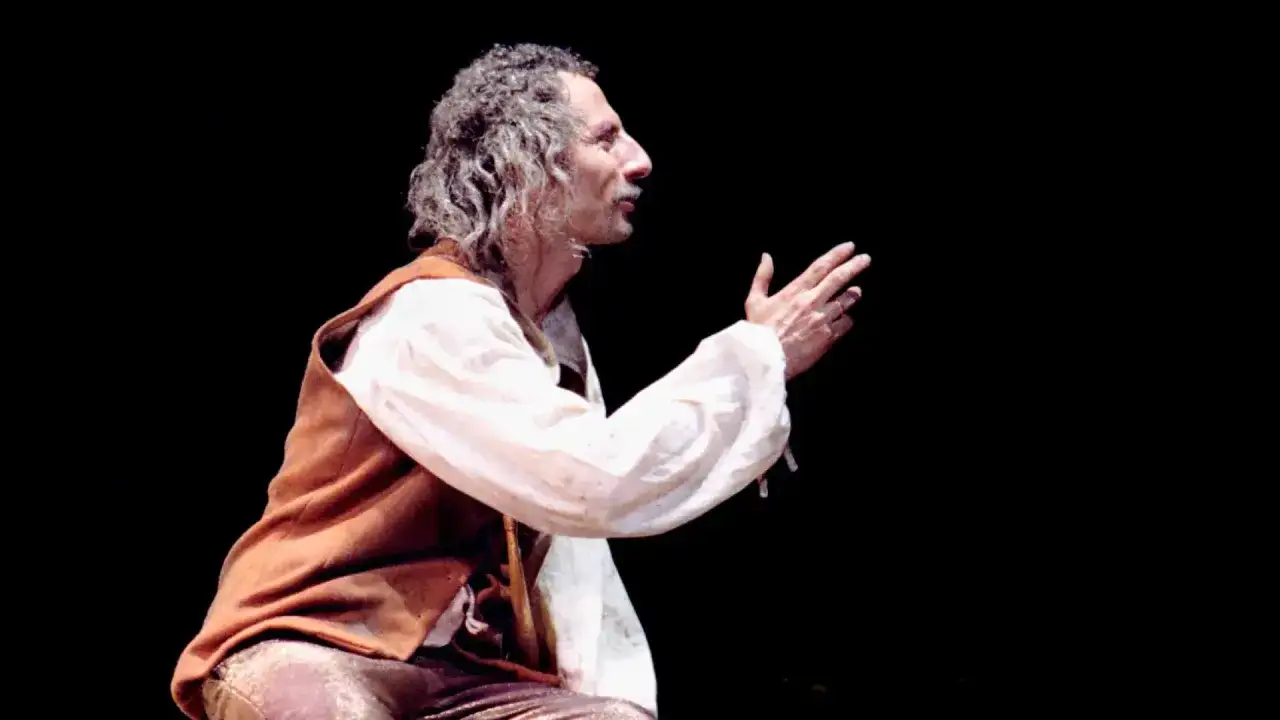 El brujo Zaragoza, con su túnica y gesto teatral, parece invocar secretos ancestrales.