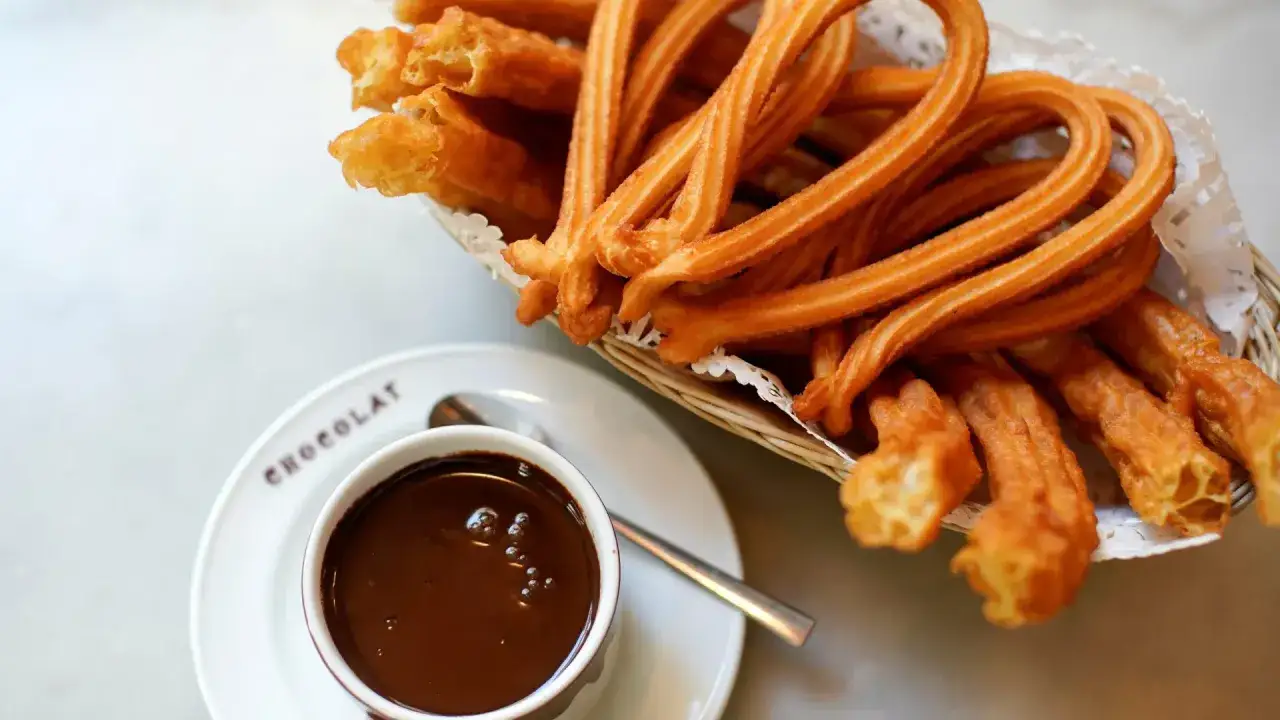 Churros recién hechos en una cesta, listos para mojar en chocolate caliente. Un placer típico de las chocolaterías de Zaragoza.