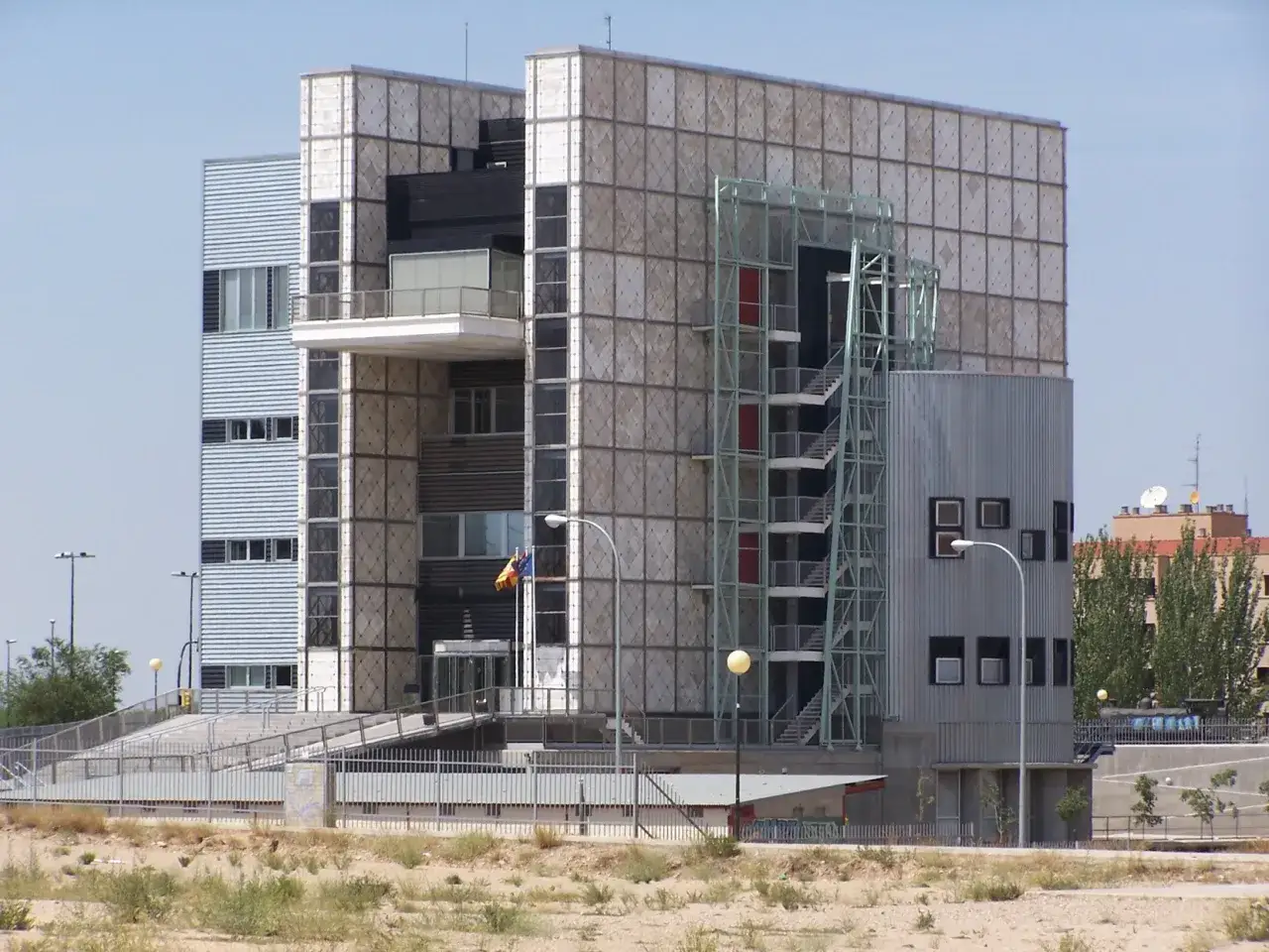 Edificio crea con fachada de paneles cuadrados y escaleras externas.