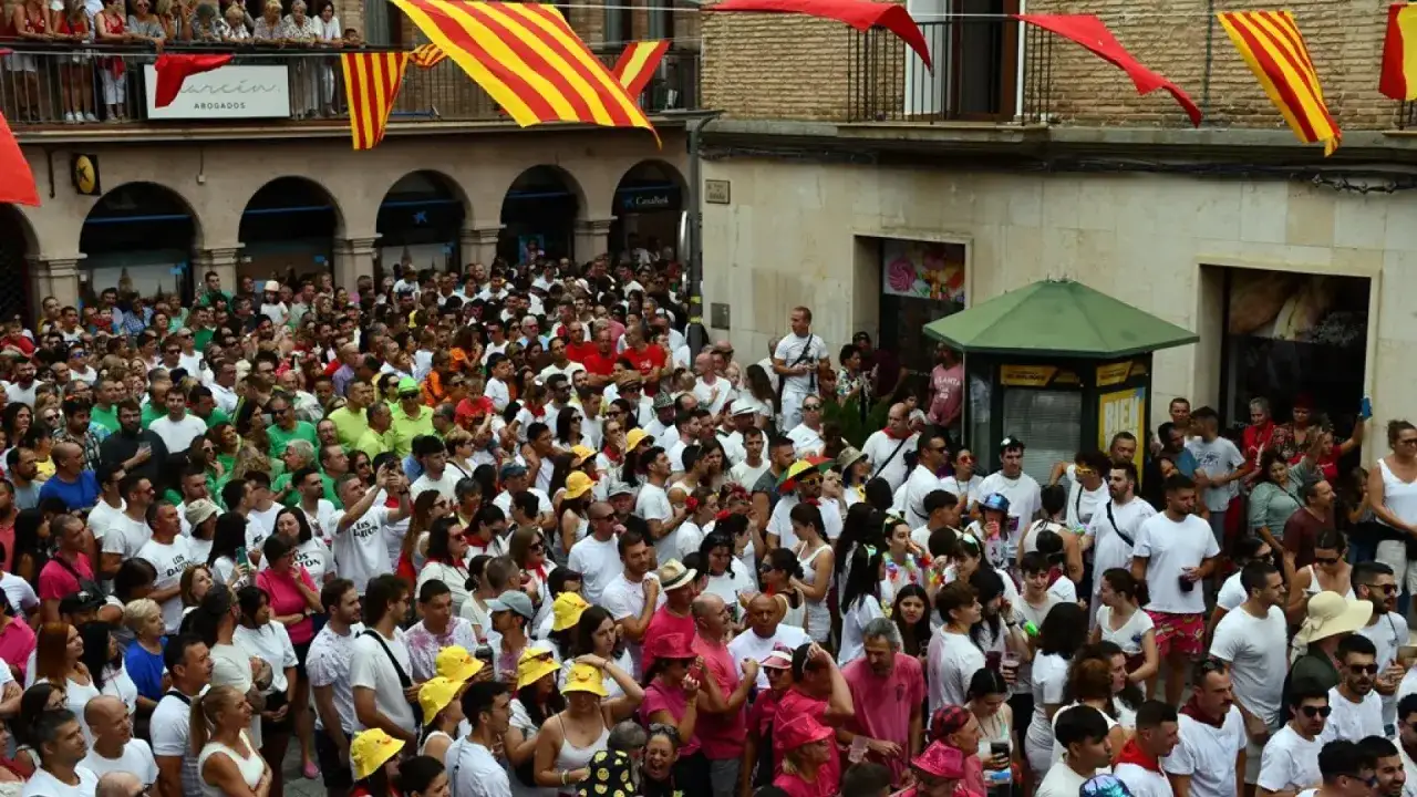 Multitud celebra las fiestas de Zuera bajo banderas rojas y amarillas.