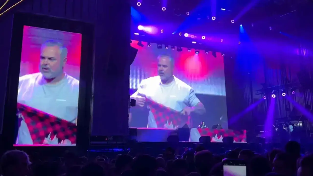 Juan Magán en concierto en Zaragoza, mostrando una tela a cuadros.