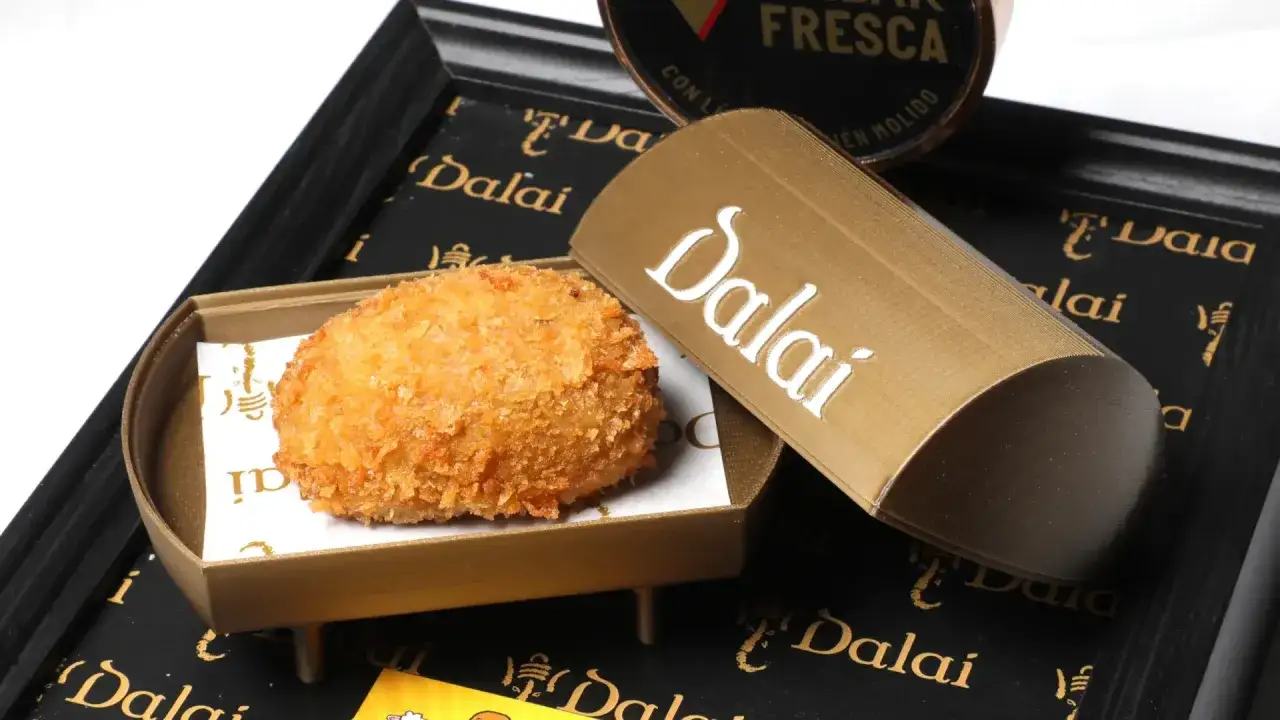Croqueta dorada y crujiente, lista para el concurso de croquetas Zaragoza. Presentada en un elegante envase de la marca Dalai.