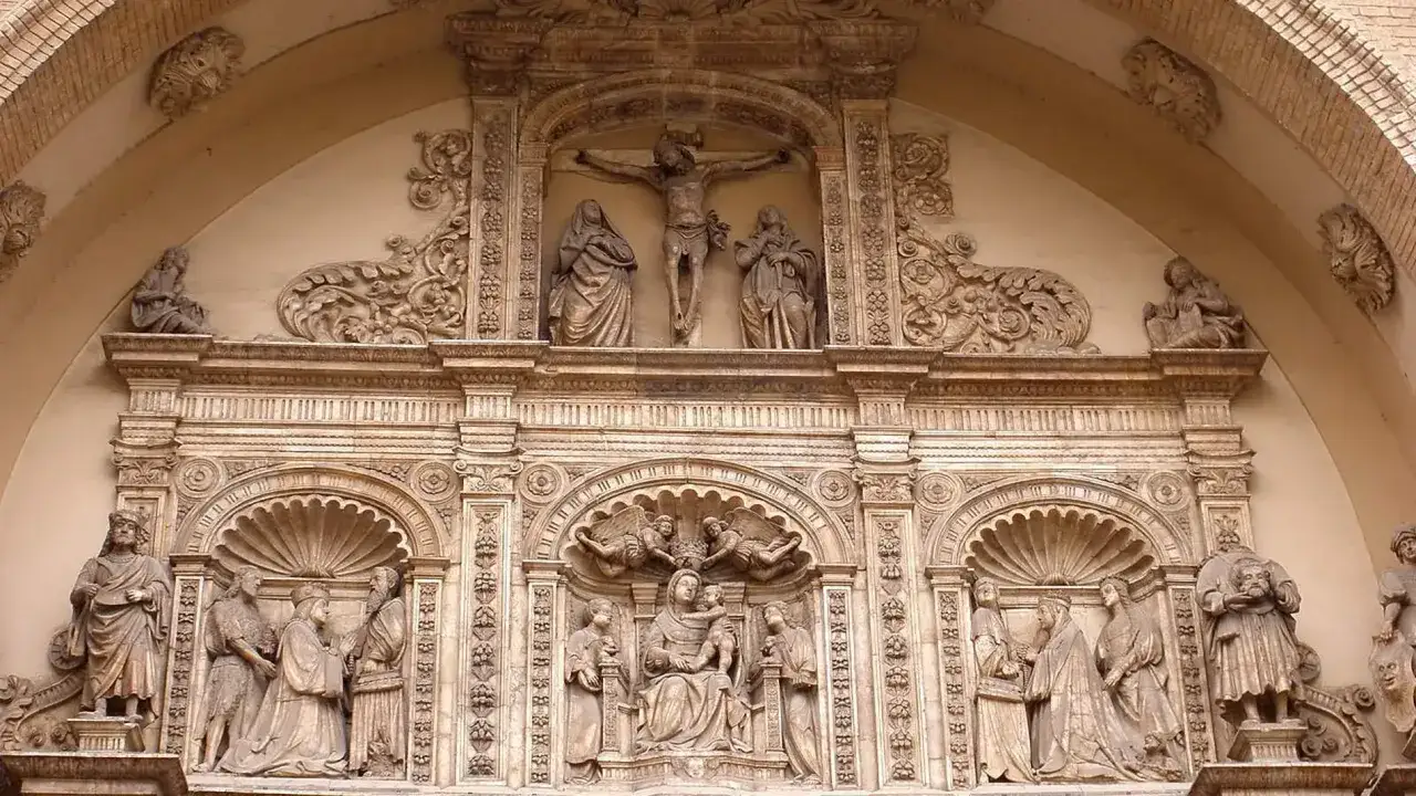 Detalle de la fachada de una iglesia en Zaragoza. Esculturas de la crucifixi&oacute;n, la Virgen con el Ni&ntilde;o y otras figuras religiosas.