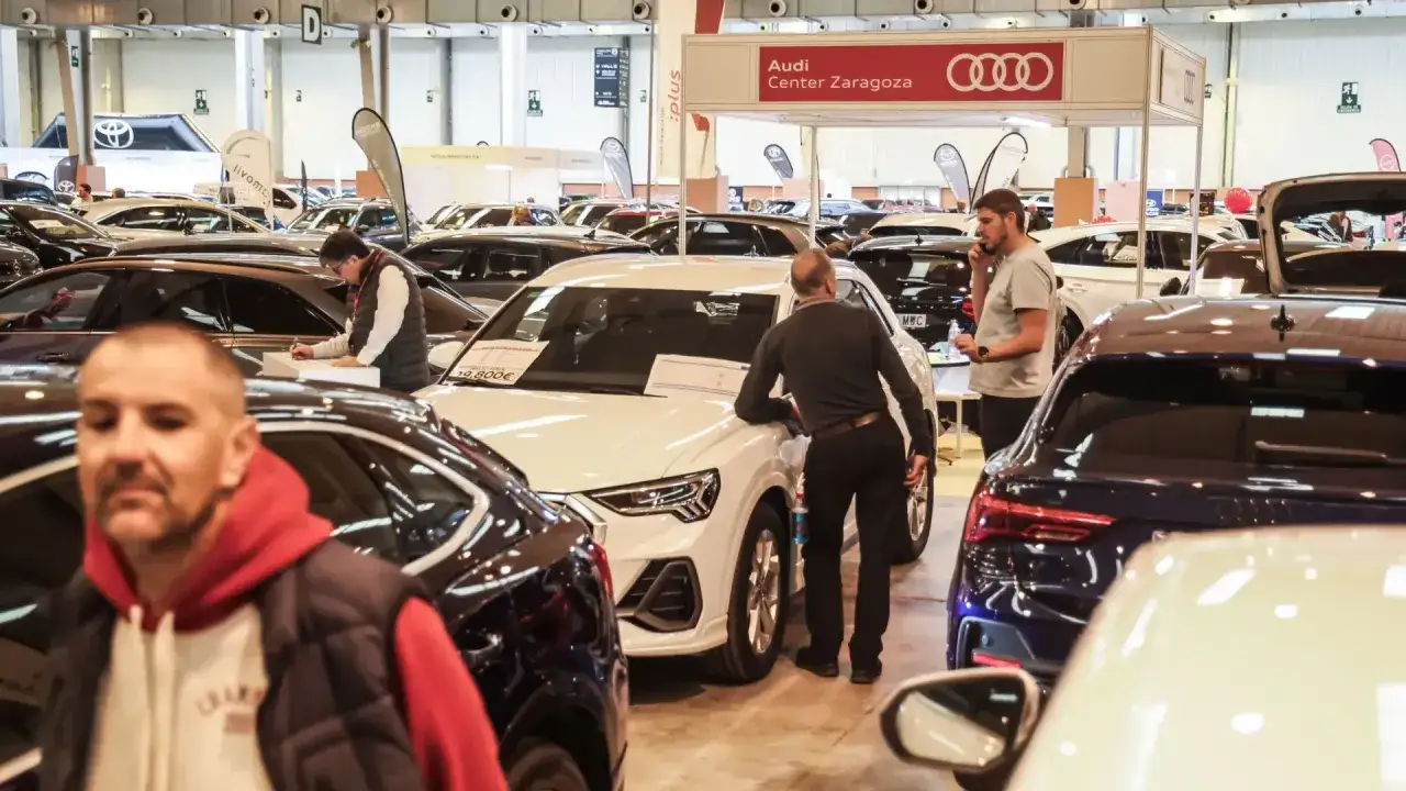 Gente observando coches en la exposicion coches zaragoza. Un hombre habla por teléfono cerca de un Audi.