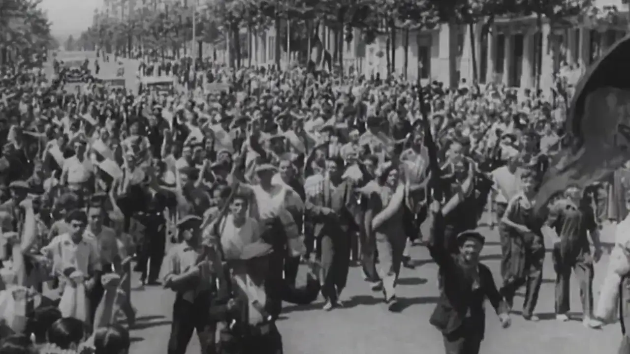 Multitud en marcha por la ruta Orwell, ondeando banderas y pancartas.