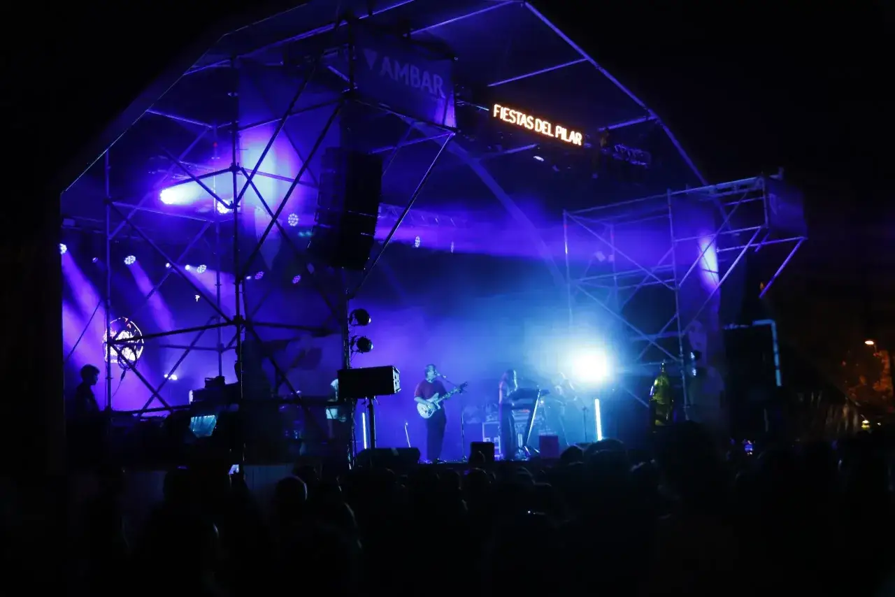 Concierto en la Estación del Norte de Zaragoza, con luces azules y el cartel de