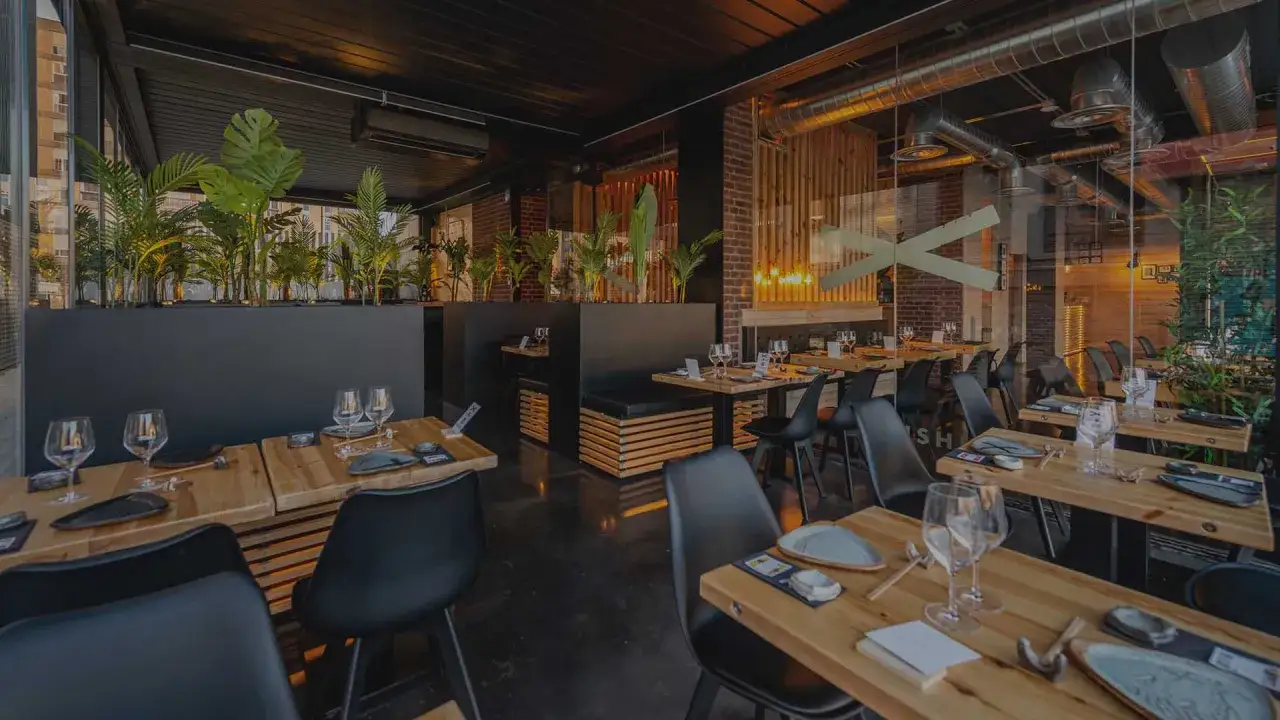 Mesas listas para disfrutar de la mejor experiencia gastronómica japonesa en Zaragoza. Ambiente moderno con plantas y detalles en madera.