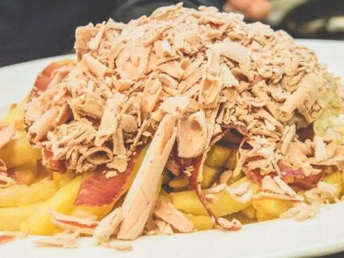 Patatas fritas con jamón y abundante atún desmigado, un plato que podría ser de los mejores huevos rotos Zaragoza.