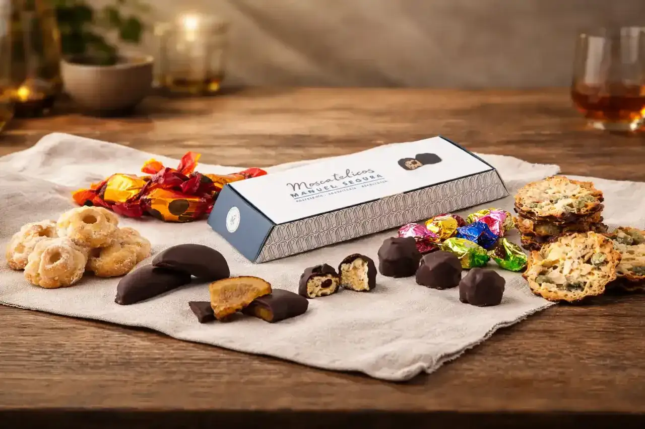 Deliciosos dulces de Aragón: bombones, galletas y caramelos envueltos en papel brillante, junto a una caja de