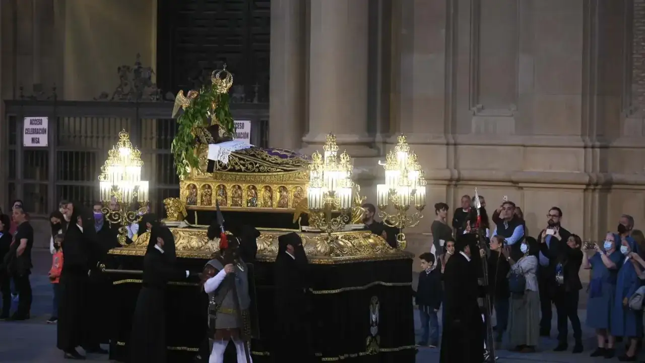 La procesión del Santo Entierro en Zaragoza avanza con un paso dorado adornado con flores y luces.
