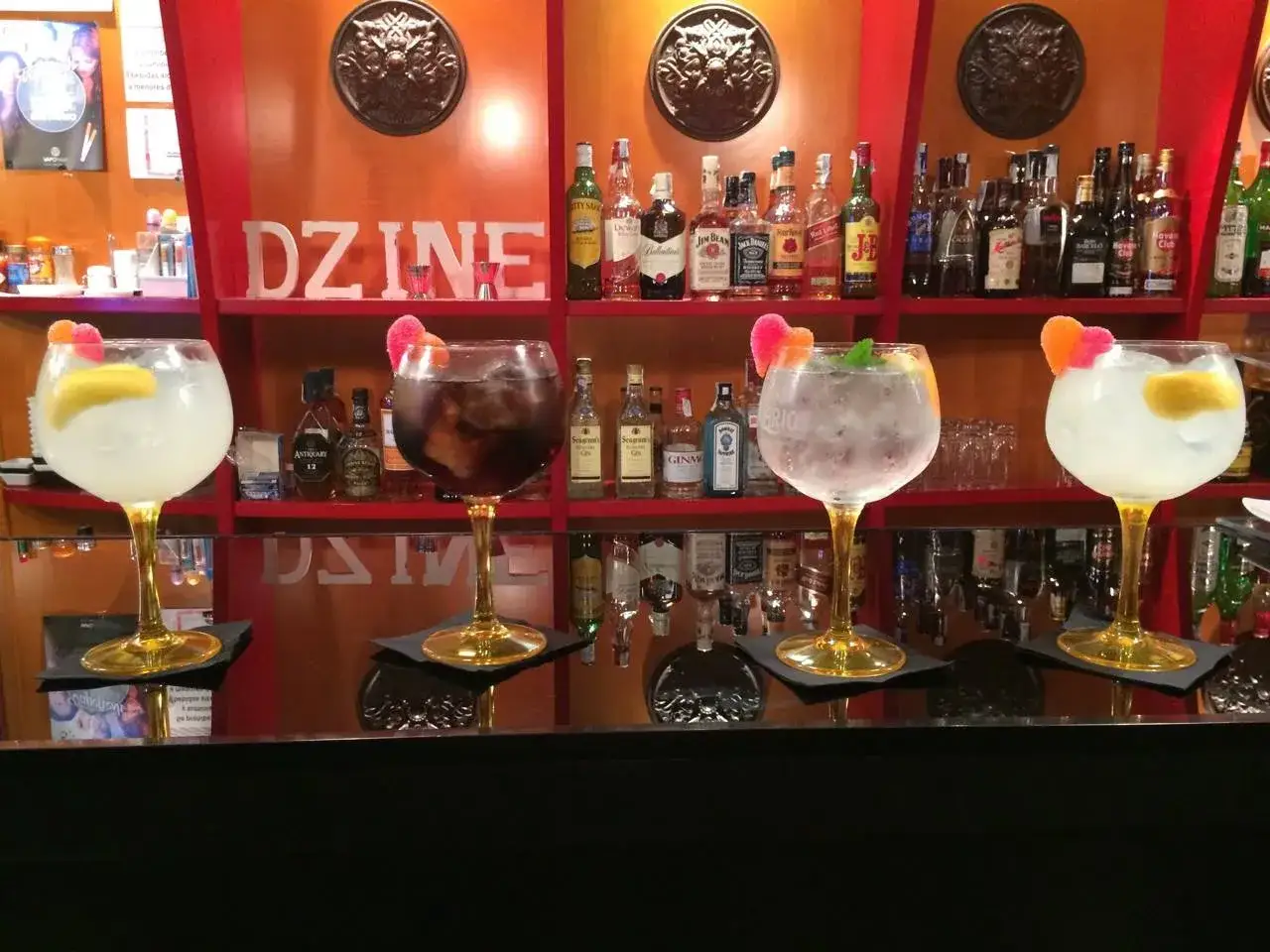 Cocteles Zaragoza: copas grandes con bebidas refrescantes y adornos de fruta, listas para disfrutar en la barra.