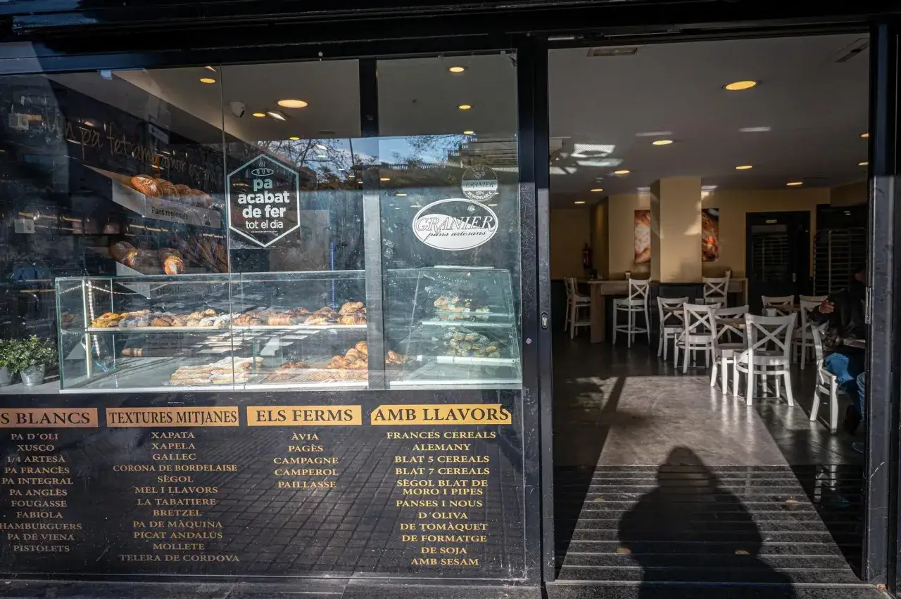 Panadería con vitrinas llenas de pan y bollería. El letrero anuncia