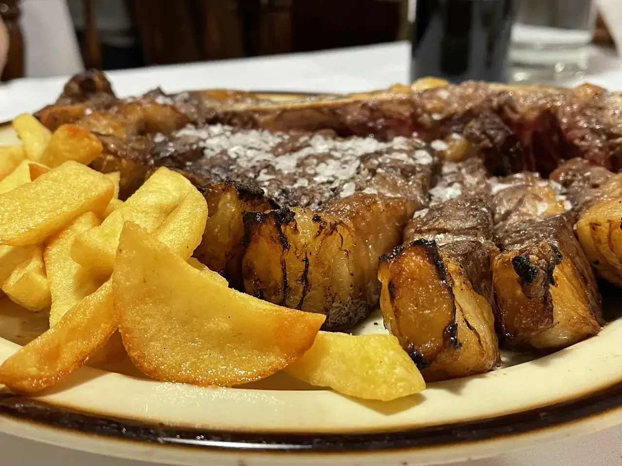 Un jugoso chuletón a la brasa con patatas fritas, perfecto para cenar en Benasque.