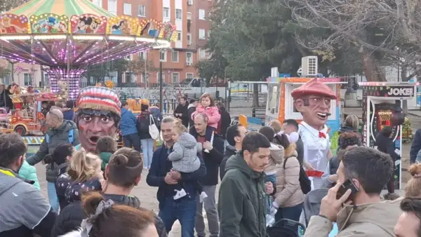 Gigantes y cabezudos animan las fiestas San José Zaragoza. Un carrusel y puestos de feria completan la escena festiva.